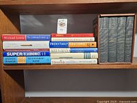 All 15 books on wooden shelf, showing spines and slipcase