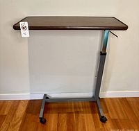 Full view of overbed table showing top, column, base, casters