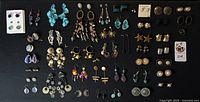 Full lot of over 45 earring pairs displayed on black background