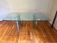 Full view of glass dining table showing top and curved bases
