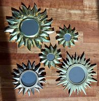 All five sunburst mirrors grouped on wood floor for size and finish comparison