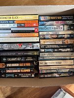 Top-down view of stacked books showing spines with titles and authors