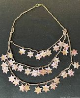 Front view of layered necklace showing star charms and chain