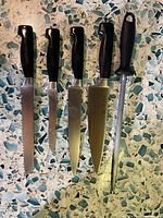 Full view of five forged knives and honing steel