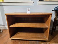 Front view of stand showing two shelves and casters