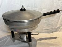 Chafing dish assembled showing pot, lid, handle, stand, burner