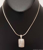 Full view of sterling silver snake chain necklace with agate pendant on display bust