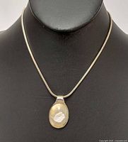 Full view of necklace on bust, showing chain and pendant