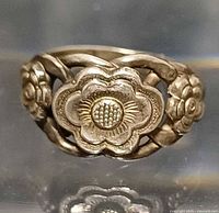 Front view of silver ring showing central flower and side roses
