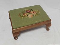 Top view showing floral gros point needlepoint and wood frame