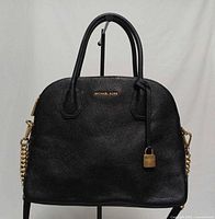 Front view of black pebbled leather Michael Kors Mercer dome satchel with gold padlock charm