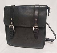 Front view showing flap, buckle straps, leather texture, stamped logo