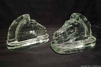 Front angle showing both glass horse head bookends side by side