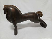 Left side view of wooden horse showing full form and tail detail