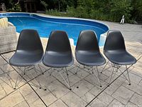 Four grey Eiffel chairs beside pool, front view