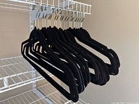 Full set of black velvet hangers on shelving