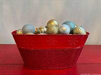 red bin filled with assorted ornaments front view