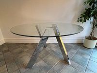 Full view of round glass table with chrome X-base
