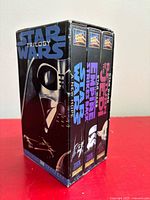 Front-left angle of boxed trilogy set showing Vader artwork and slipcase condition
