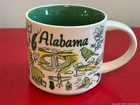 Right side view showing Alabama text, waterfall, aircraft, canoe graphics, green interior