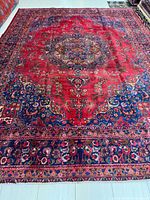 Full view of the rug showing red field, navy border and overall design