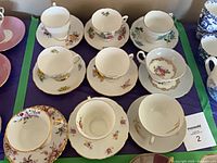All nine teacup and saucer duos arranged in three rows