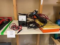 Shelf view showing multimeter, glue gun, staple gun, rotary tool and accessories