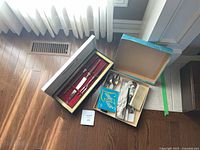 Closed and open carving set box and additional flatware box displayed on floor