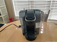 Front view showing Keurig branding, digital screen, buttons, reservoir, drip tray