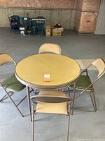 Full view of round folding table with four chairs