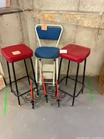 Front view of two red stools and blue chair
