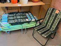 Folded chairs stacked on cushions next to an opened chair