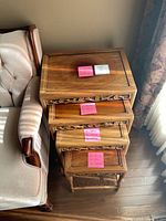 Stacked set of four carved hardwood nesting tables beside sofa