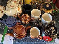 Group shot of all teapots and mugs on countertop