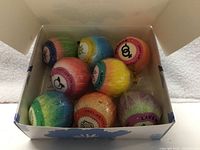 Open box showing eight wrapped bath bombs