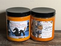 Front view of both candles showing labels and lids