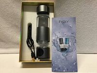 Open box showing bottle, USB cable, brochure