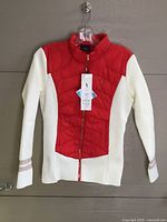 Front view of LPGA red and white quilted coat on hanger with tag visible
