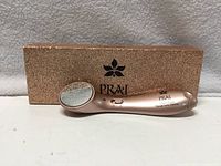 Device resting on front of glitter presentation box; brand name visible