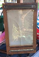 Front view showing cracked glass panel and metal paper clamps