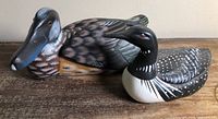 Wooden duck and ceramic mallard side by side on tabletop