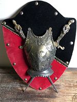 Front view of shield with breastplate and daggers inserted