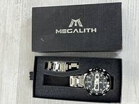 Watch inside Megalith branded box with spare link visible