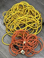 Yellow and orange extension cords coiled on floor