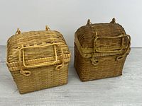 Front view of both rectangular woven baskets with lids closed and handles shown