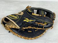 Full view of black Reebok Pennant Series glove showing logo, lacing and overall condition