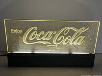 Illuminated view showing acrylic panel glowing and Coca-Cola script