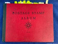 Front cover of red postage stamp album with title visible