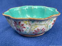Full view of fluted bowl showing turquoise interior and exterior floral enamels