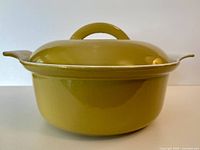 Side view of mustard yellow Descoware Dutch oven with lid on